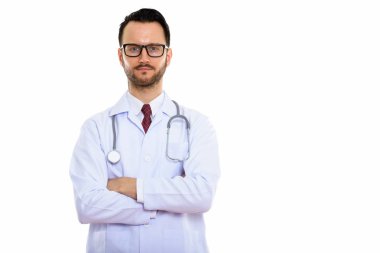 Kollarını kavuşturmuş genç bir doktorun stüdyo fotoğrafı.