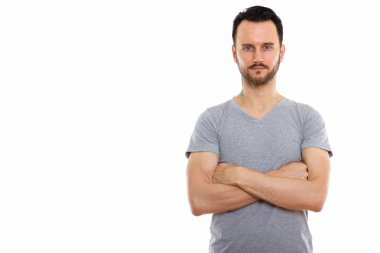 Kollarını kavuşturmuş genç bir adamın stüdyo fotoğrafı.