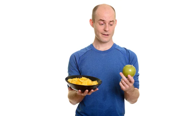 Homem caucasiano careca escolhendo entre tigela de batatas fritas e gr — Fotografia de Stock