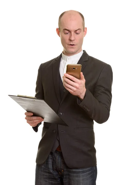 Łysy Biały Biznesmen Trzymając Schowek Podczas Korzystania Telefonu Komórkowego — Zdjęcie stockowe