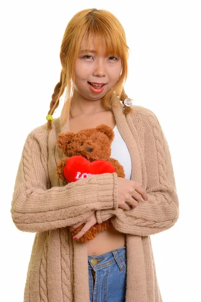 年轻快乐的亚洲女人带着爱心和爱心微笑拥抱泰迪熊 — 图库照片