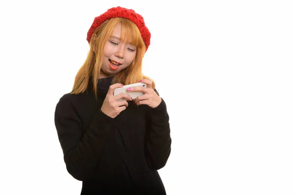若い幸せなアジアの女性は笑顔と携帯電話を使用して — ストック写真