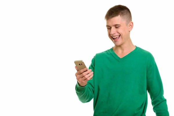 Молодий кавказький чоловік посміхається і тримає мобільний телефон. — стокове фото