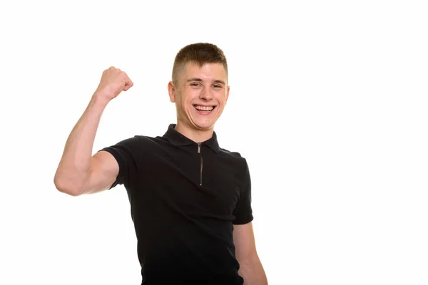 Ung glad kaukasisk man ler och böjande arm — Stockfoto