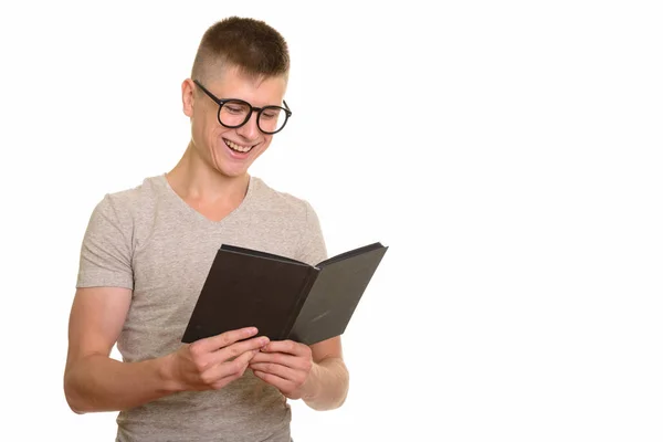 Young happy Caucasian man smiling and reading book — Stock Photo, Image