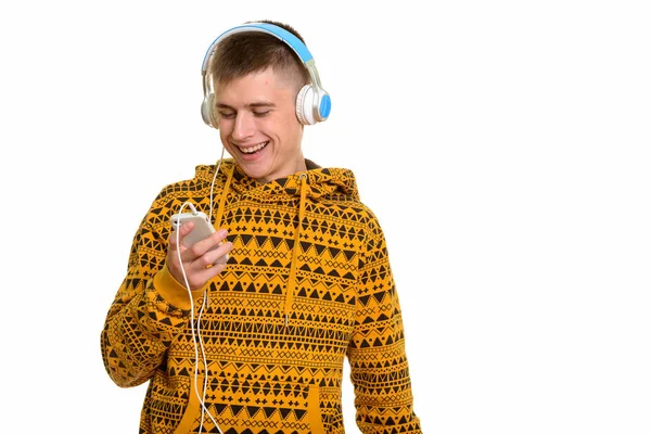 Jeune homme heureux caucasien souriant tout en utilisant le téléphone mobile et l — Photo