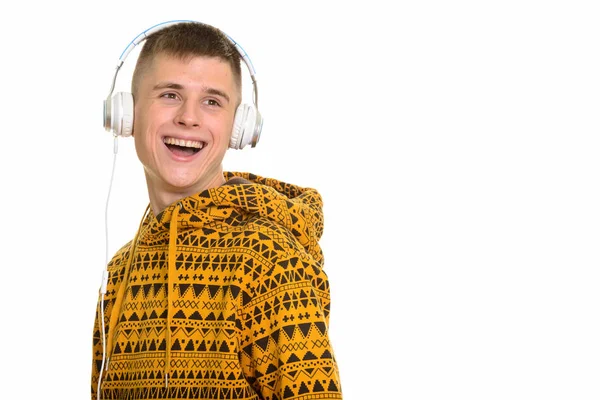 Thoughtful young happy Caucasian man smiling while listening to — Stock Photo, Image
