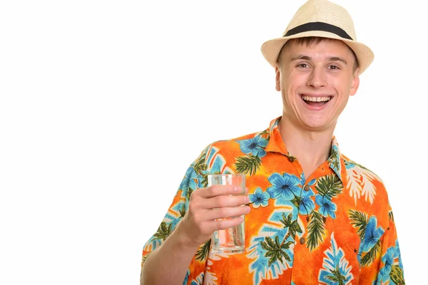 Young happy Caucasian man smiling and holding glass of water — Stock Photo, Image