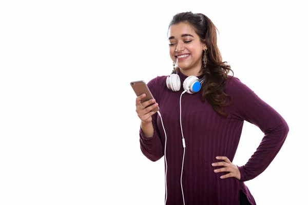 Fiatal Boldog Indiai Mosolyog Miközben Fejhallgatót Visel Nyakában Miközben Mobiltelefont — Stock Fotó
