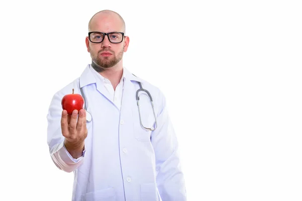 Estúdio Tiro Jovem Homem Muscular Careca Médico Segurando Maçã Vermelha — Fotografia de Stock