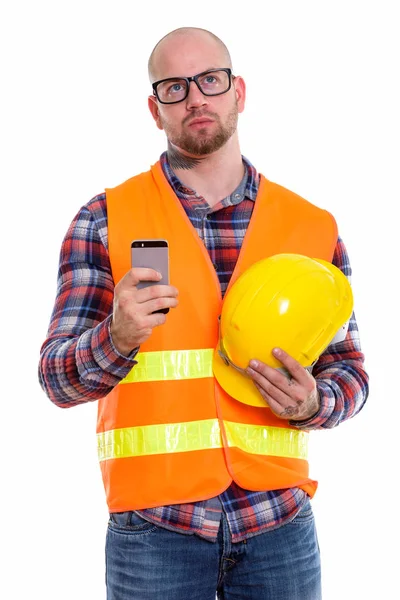 Thoughtful Bald Muscular Man Construction Worker Holding Safety Helmet Mobile — Stock Photo, Image