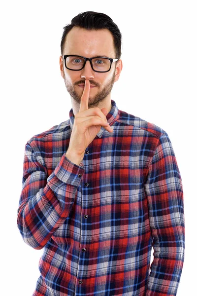 Dudağında parmak olan genç adamın stüdyo fotoğrafı.