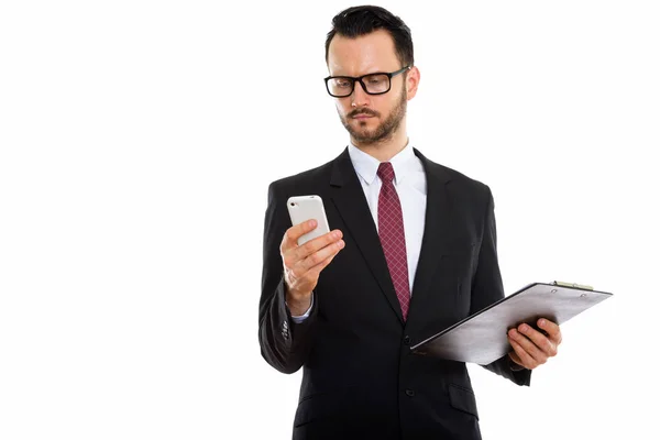 Студийный Снимок Молодого Бизнесмена Держащего Планшет Используя Мобильный Телефон — стоковое фото