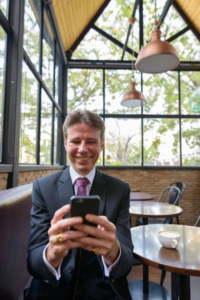Счастливый Бизнесмен Улыбается Пользуется Мобильным Телефоном Кафе — стоковое фото