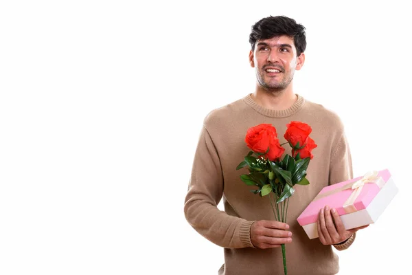 Pensativo Joven Feliz Persa Hombre Sonriendo Mientras Sostiene Rosas Rojas — Foto de Stock