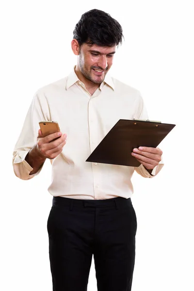 Joven Empresario Persa Feliz Sonriendo Leyendo Portapapeles Mientras Sostiene Teléfono —  Fotos de Stock