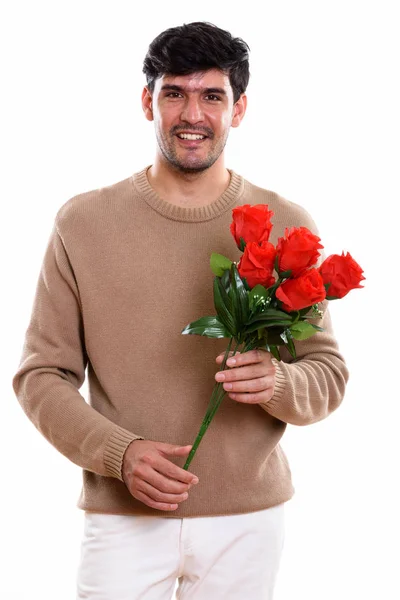演播室里年轻快乐的波斯男人微笑着捧着红玫瑰迎接情人节的镜头 — 图库照片
