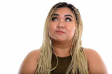 Genç şişman Asyalı kadının yukarı bakarken düşündüğü bir stüdyo fotoğrafı.