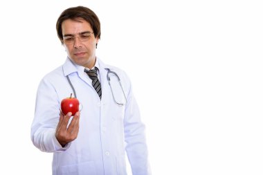 Genç İranlı doktorun kırmızı elmayı tutarken ve ona bakarken çekilmiş bir fotoğraf.