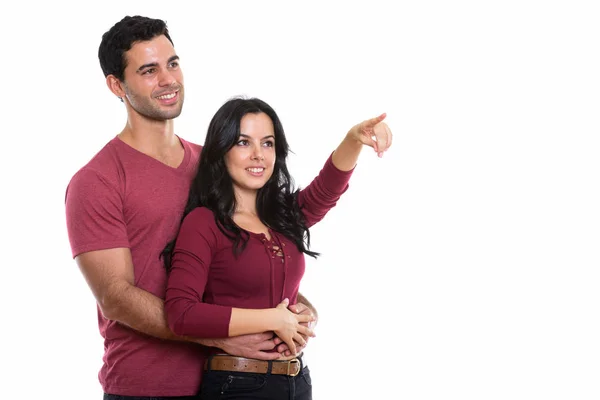 距離を指している女性と抱き合って笑っている間に思慮深い若い幸せなカップル — ストック写真