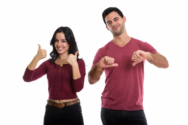 演播室拍摄到一对年轻快乐的夫妇笑着 女人竖起大拇指 男人放下大拇指 — 图库照片