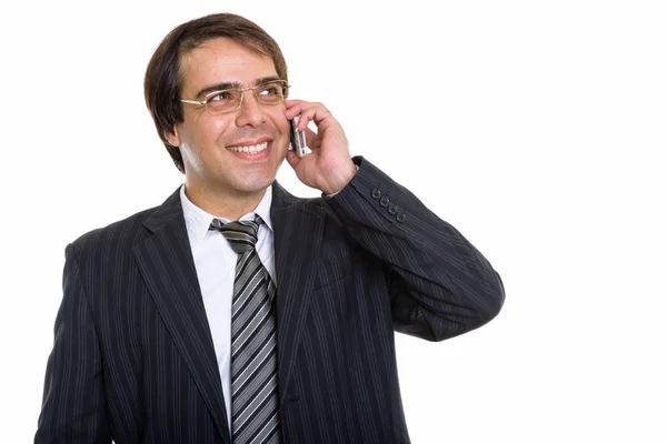 若い幸せなペルシャのビジネスマンのスタジオショット笑顔と携帯電話で話していると思いながら — ストック写真