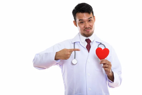 亚洲年轻男医生举着红心指着红心的演播室镜头 — 图库照片