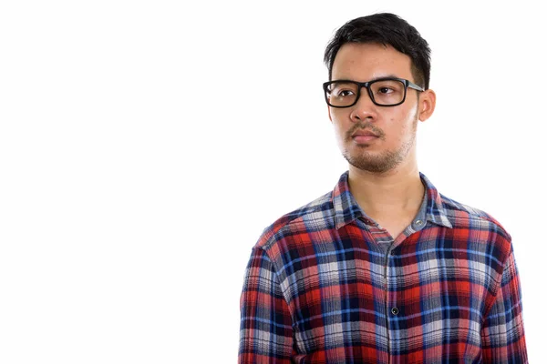 Genç Asyalı Adamın Gözlük Takarken Düşünüp Uzaklaştığı Bir Stüdyo Fotoğrafı — Stok fotoğraf