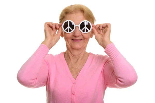 快乐的老年妇女微笑着举着印有和平标志的太阳镜 — 图库照片