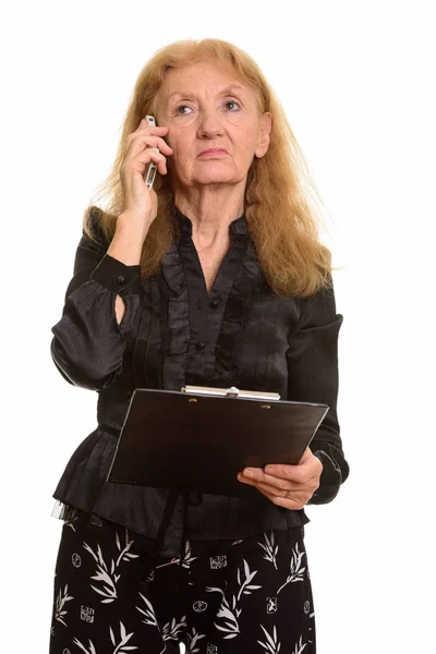 Studio Zdjęcie Starszej Bizneswoman Trzymając Schowek Podczas Rozmowy Przez Telefon — Zdjęcie stockowe