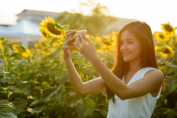 Joven feliz mujer asiática sonriendo mientras toma foto selfie con —  Fotos de Stock