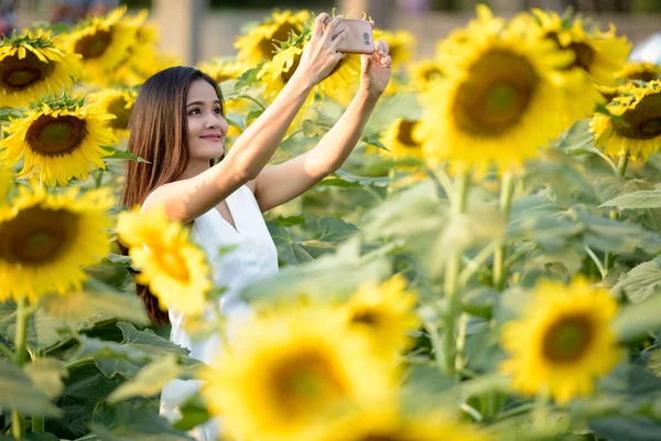 Joven feliz mujer asiática sonriendo mientras toma foto selfie con —  Fotos de Stock