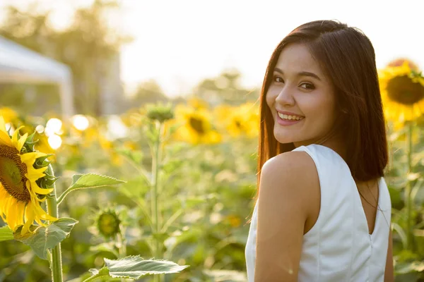 Joven mujer asiática feliz sonriendo y mirando hacia atrás en el campo de —  Fotos de Stock
