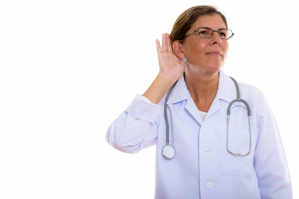 Studio shot de mature belle femme médecin écoute tandis que thi — Photo