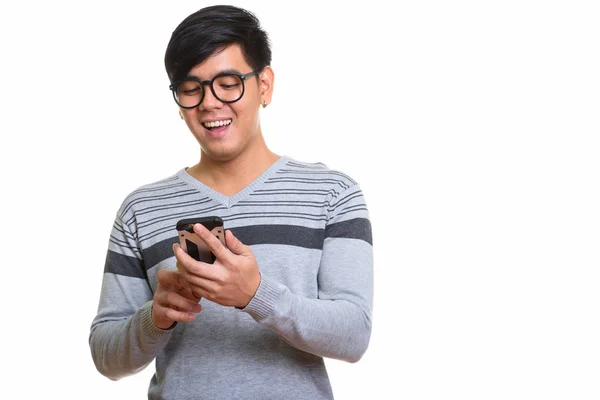 Студія постріл щасливі азіатських людині посміхаючись під час використання мобільного телефону — стокове фото