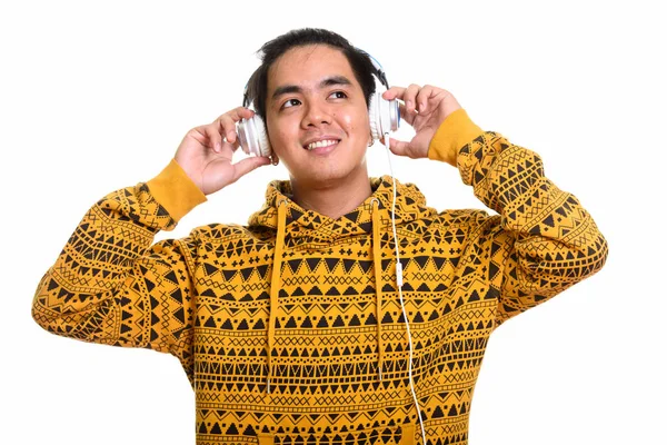 Réfléchi heureux asiatique homme souriant tout en écoutant de la musique — Photo