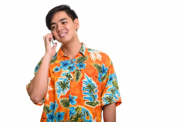 Jeune homme asiatique heureux souriant et parlant sur téléphone mobile — Photo
