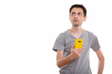 Genç adam cep telefonuyla düşünme ve l sırasında stüdyo çekim