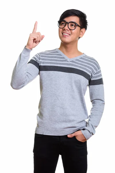 Studio shot de heureux asiatique homme souriant et pointant doigt vers le haut wh — Photo