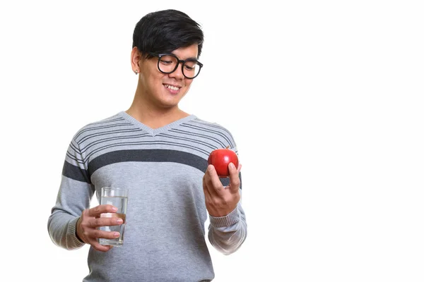 Feliz ásia homem sorrindo e olhando para vermelho maçã enquanto segurando g — Fotografia de Stock