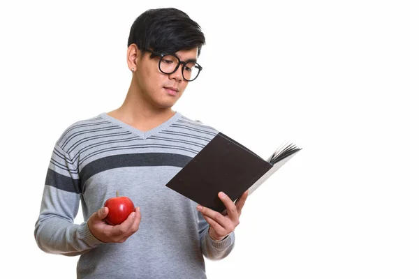 Strzał studio przystojny mężczyzna Azji, czytanie książki, trzymając czerwony — Zdjęcie stockowe