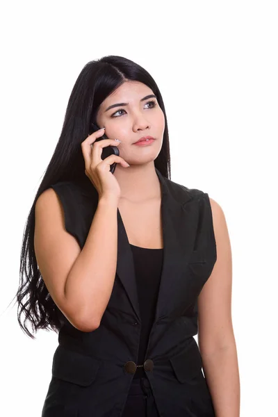 Studioaufnahme einer jungen asiatischen Frau, die auf einem Handy spricht, während — Stockfoto