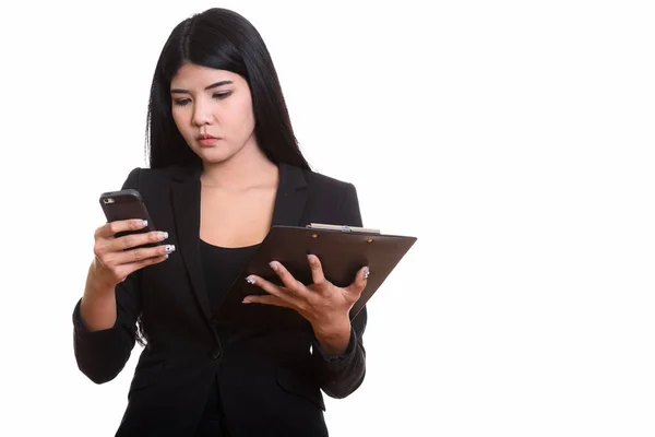 Studio shot de jeune femme d'affaires asiatique à l'aide de téléphone mobile whil — Photo