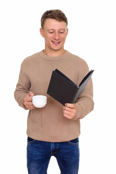 Studio ampui nuorta onnellista valkoihoista miestä lukemassa kirjaa ja pitämässä — kuvapankkivalokuva