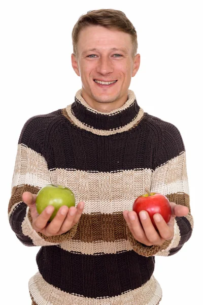 Studio shot of young happy Caucasian man holding green and red a — Stock Photo, Image