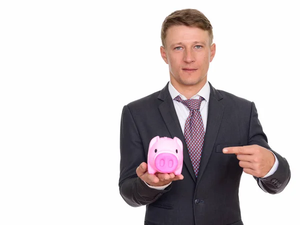 Studioaufnahme eines jungen gutaussehenden kaukasischen Geschäftsmannes, der Schweine hält — Stockfoto
