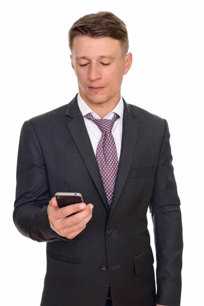 Studio shot of young handsome Caucasian businessman holding mobi — Stock Photo, Image