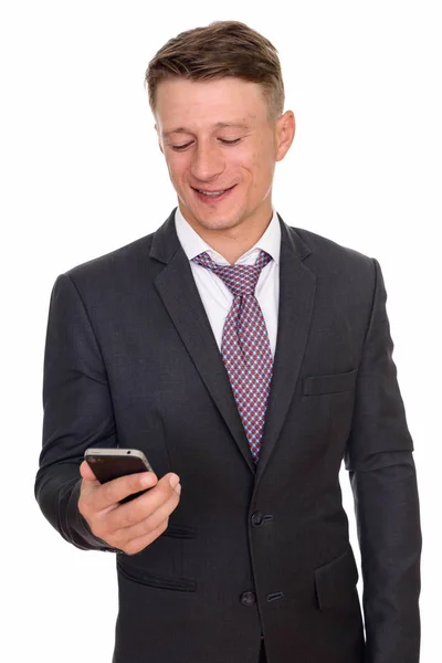 Studio shot of young happy Caucasian businessman holding mobile — Stock Photo, Image