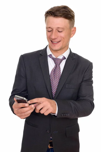 Studio shot of young happy Caucasian businessman using mobile ph — Stock Photo, Image