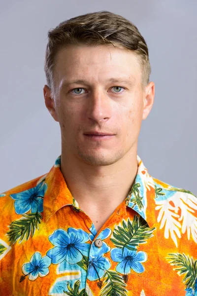 Portrait shot of young handsome Caucasian man in Hawaiian shirt — Stock Photo, Image